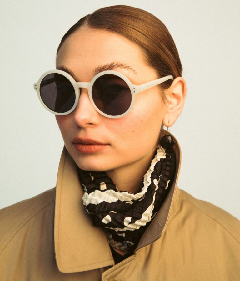 A person wearing sunglasses in a snowy winter landscape for eye protection